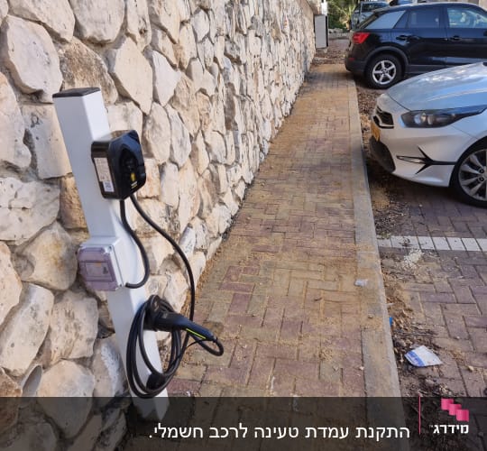 עמדת טעינה לרכב חשמלי ליד מדרכה